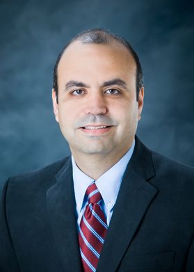 smiling man with balding hair in a suit and tie