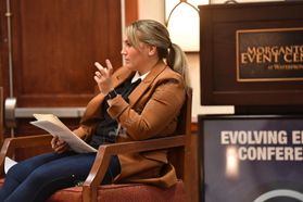 WVU Faculty and Student Innovation Executive Director Erienne Olesh sits in a chair during a conversation during the 2022 Evolving Energy Conference. She is wearing a brown jacket and navy blue pants. Her blond hair it pulled back in a pony tail.