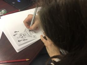 a girl draws a robot with question marks around it