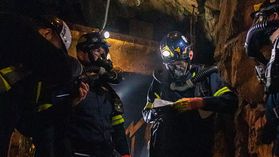 Several members of the WVU Mine Rescue Team are shown in a dark mine setting.