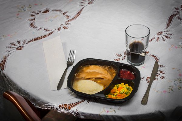 Plate of food on a table with silverware and a glass
