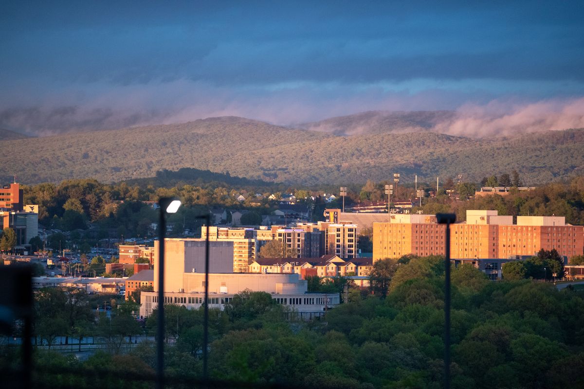 The Evansdale Campus is shown from the river side of Morgantown. The Creative Arts Center is in the foreground with Towers on the right and hills in the background.