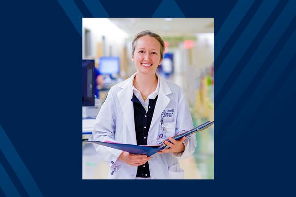 Dr. Jackie Grimes Anderson in white coat with open blue notebook