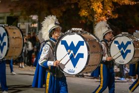 Members of the Mountaineer Marching Band playing bass drums participate in the 2022 Homecoming Parade.