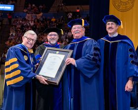 WVU President Gordon Gee presents an honorary degree to Noel Doheny alongside Eberly College Dean Gregory Dunaway and Faculty Senate Chair Scott Wayne.ege 
