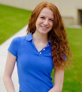 Girl smiling in blue shirt.
