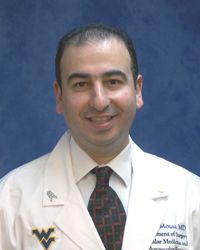 a smiling man with dark hair wearing a WVU Medicine white coat