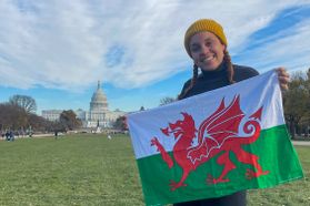 girl in toboggan holds Wales flag in front of U.S. Capitol