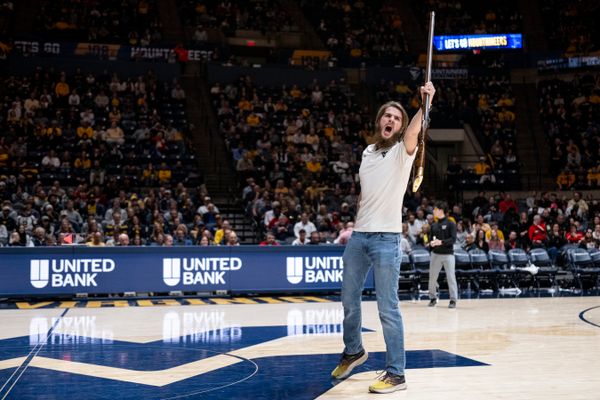 Braden Adkins holds the Mountaineer mascot rifle in his hand while leading a cheer from center court at the Coliseum.