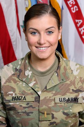 smiling woman, combat fatigues, flags in background
