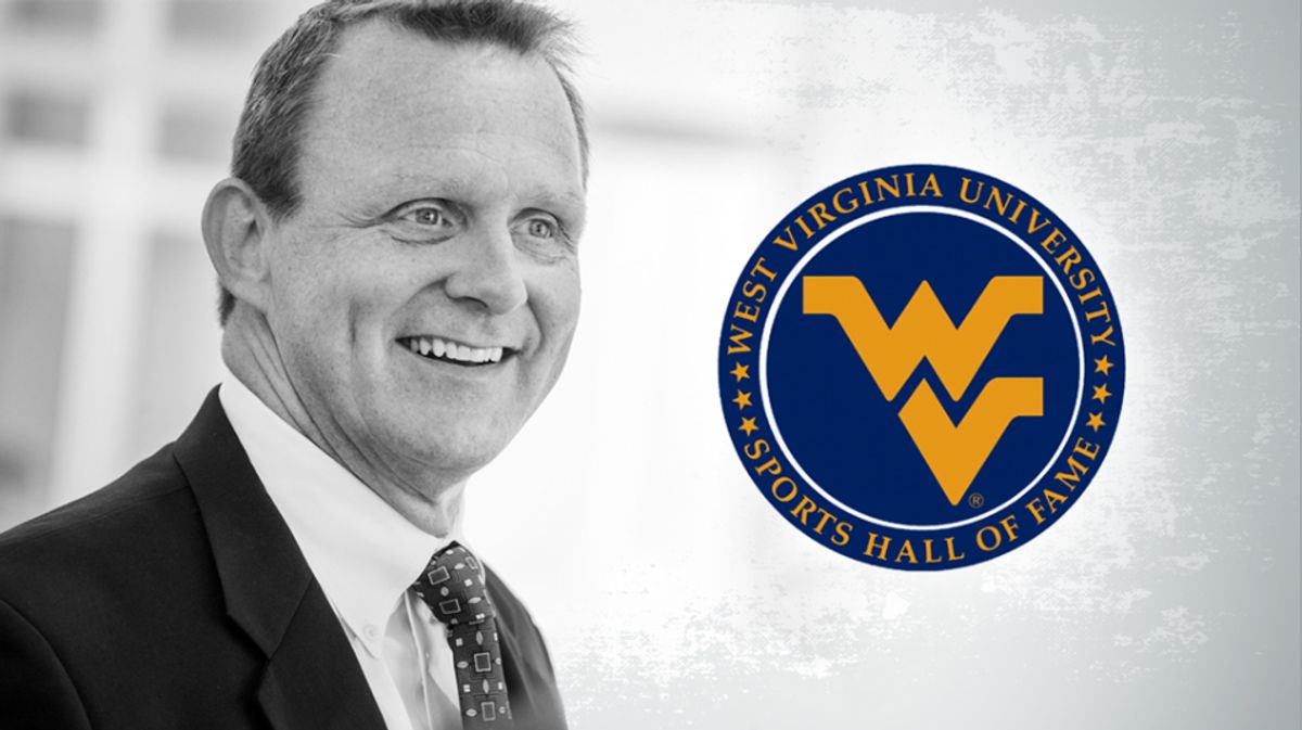 Black and white picture of man in suit with a blue and gold flying WV logo on the right