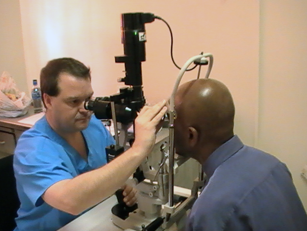 eye doctor checks a patient's eyes with equipment 