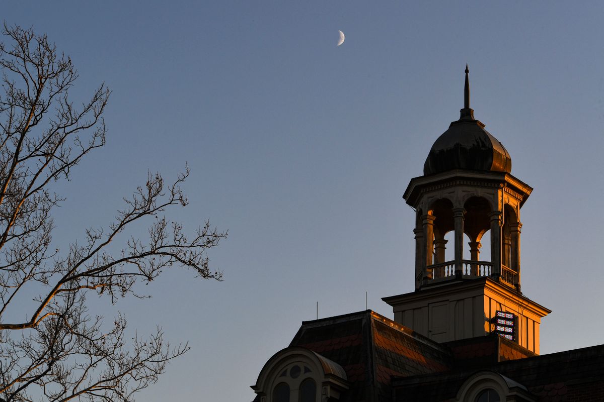 Crescent moon shown over top of building