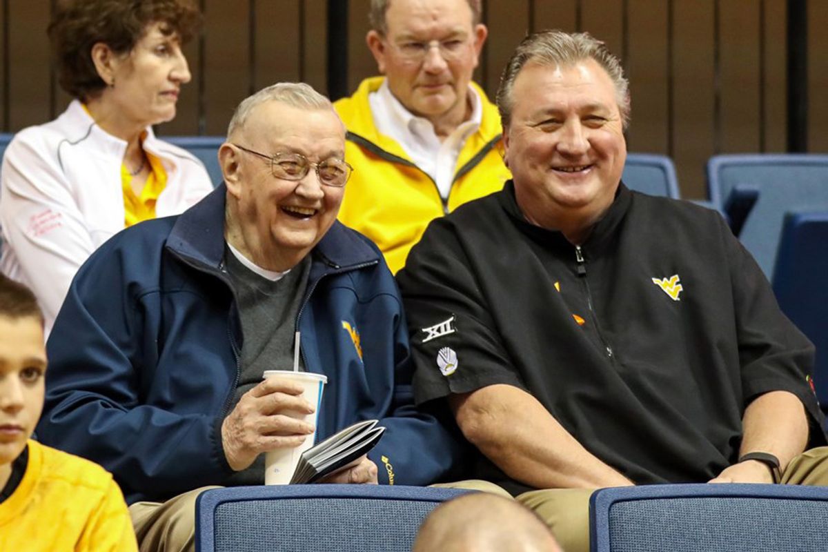 two older men sitting in stands
