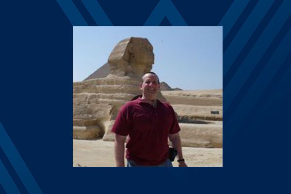 man stands in front of sphynx