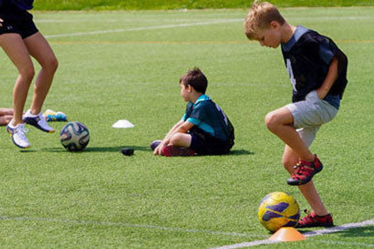 child with soccer ball, child sitting, legs and soccer ball