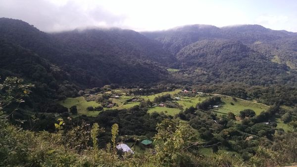 A vista of the Cloud Region of Costa Rica. The picture shows a verdant valley surrounded by thickly forested mountains. 