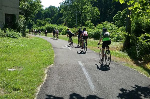 A line of cyclists on a paved trail