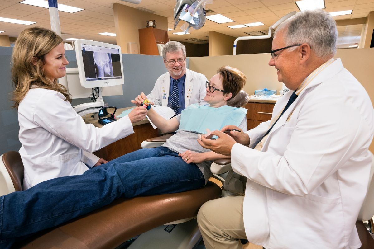 Dental professionals sitting with patient
