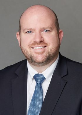 man with trimmed beard, suit coat, blue tie, white shirt