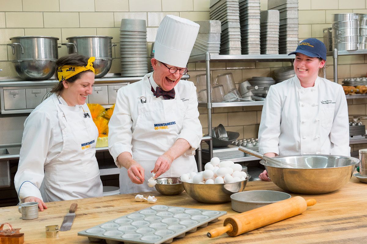 President Gordon Gee dressed as a chef cracking eggs.