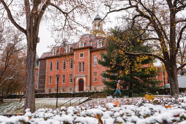 WVU student walks by Martin Hall on a snowy day.