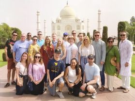 A group of students stand in front of the Taj Mahal