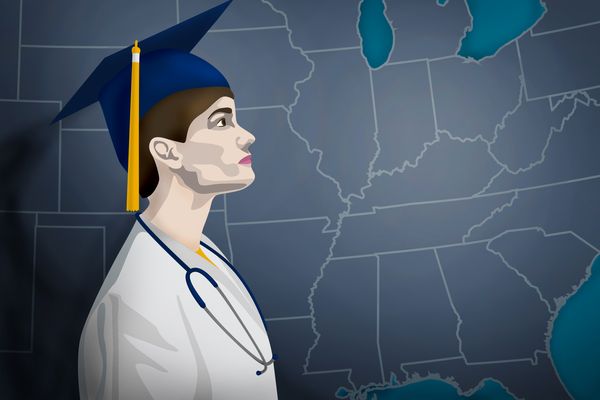 woman in mortarboard looks at map of US
