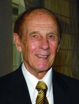 Headshot of longtime WVU supporter Don Hoylman. He is pictured in a black jacket, white dress shirt and blue and gold striped tie. 