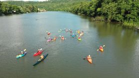 photo of several different-colored kayaks on a river