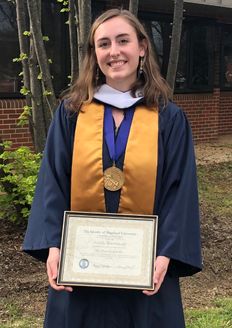 Scholarship recipient Isabella Hawkinberry is pictured wearing a dark blue graduation gown with a gold sash and a gold medal on a purple ribbon. She is holding her framed diploma. 