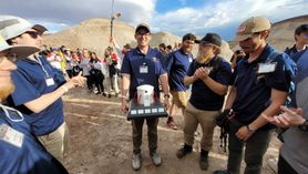 Five members of the University Rover Challenge from WVU celebrate around the first-place trophy.