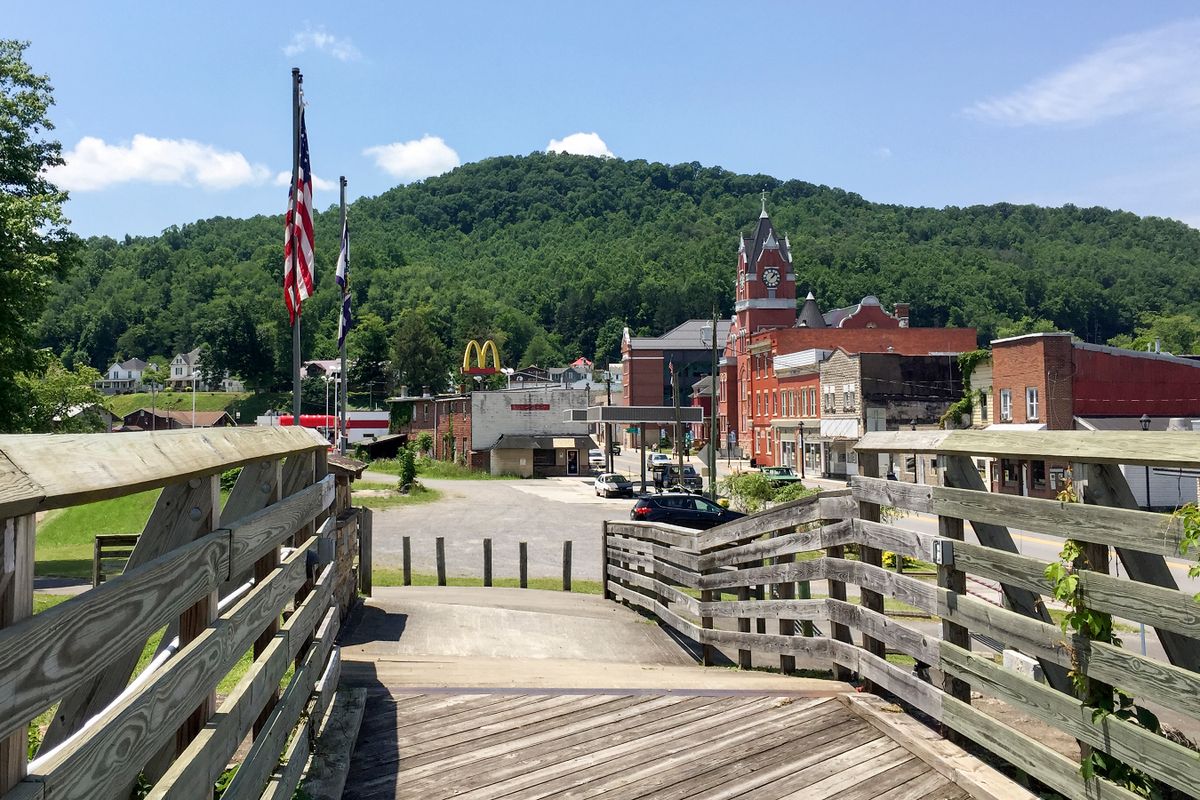 A small town at the foot of a mountain with a boardwalk in the foreground