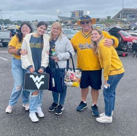 The Johnson family poses for a photo together while tailgating for a WVU football game. 