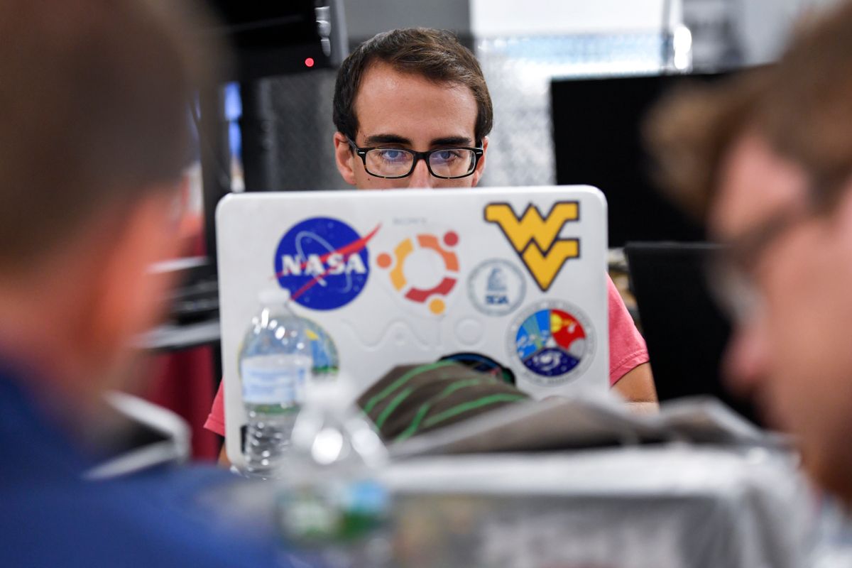 WVU programmer sitting in front of computer.