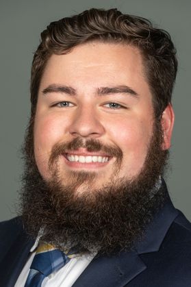 smiling man with heavy beard, dark hair