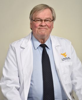 man wearing glasses in a white lab coat