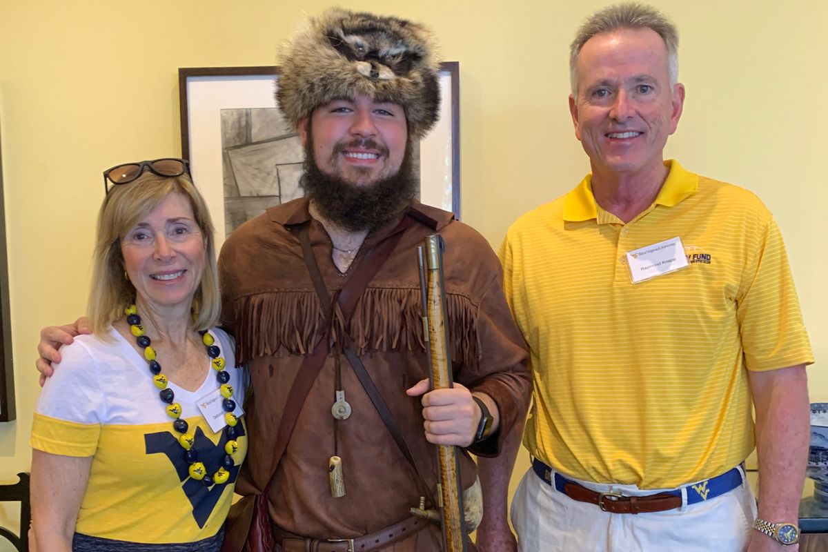 woman, man flank man dressed in buckskins and coonskin cap