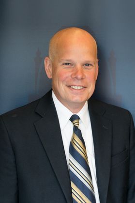 smiling bald man in suit and tie