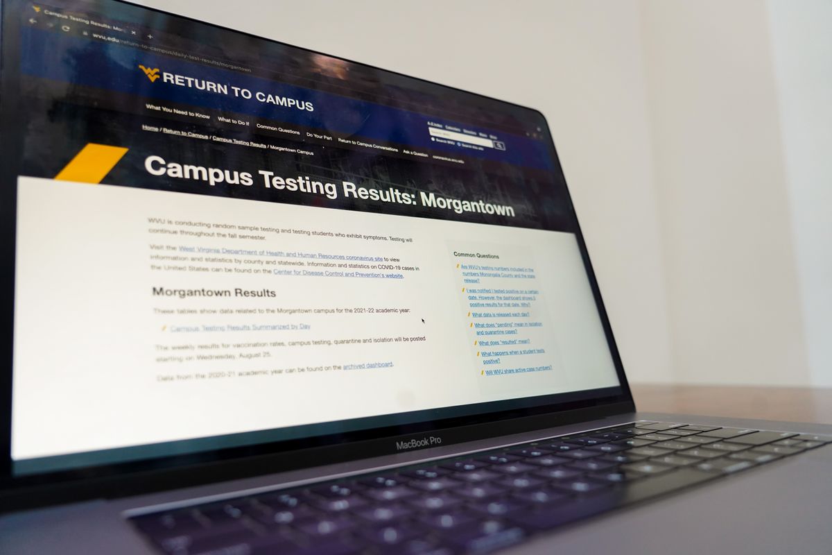 A laptop computer shows a screen that reads in a blue banner 'Campus Testing Results: Morgantown'