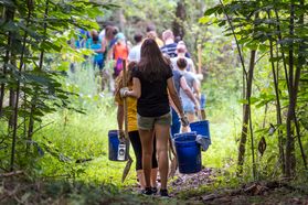 Freshmen Honors students carry buckets, shovels and other supplies as they walk into the Core Arboretum in August 2016 to participate in their Service Day.