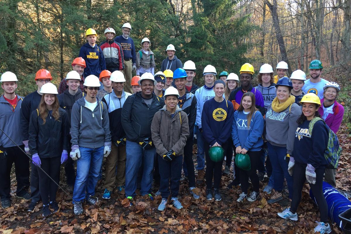 group of students in forest wearing hard hats