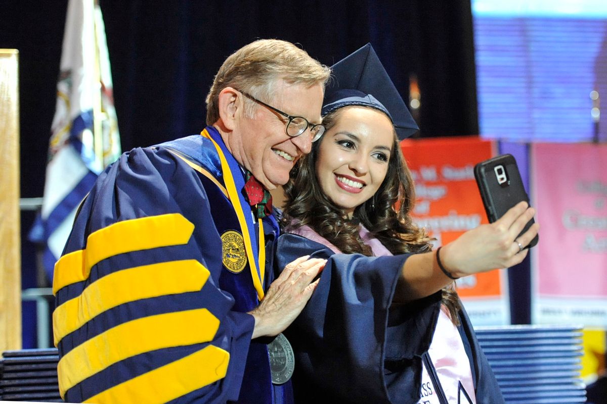 Gee takes selfie with student during Dec. 2016 Commencement 