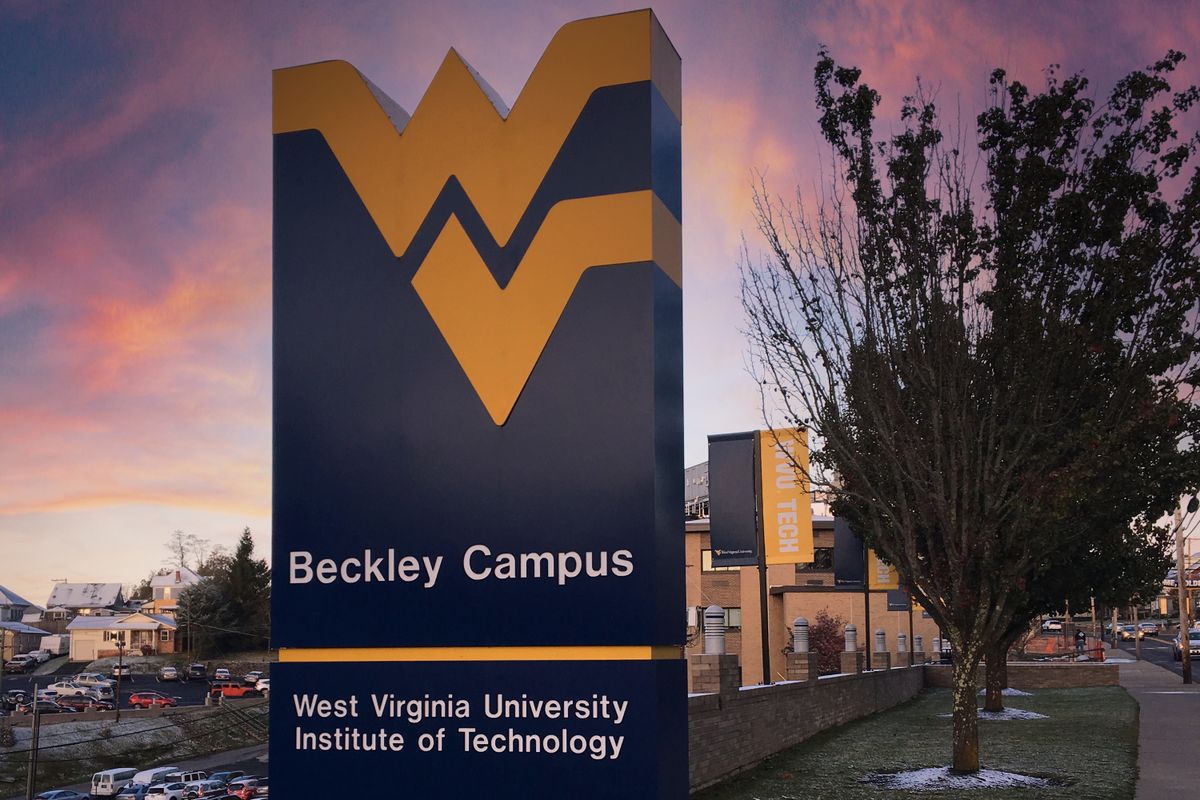A sign with a gold Flying WV at the top and the words 'Beckley Campus' in white lettering is shown against a pink and purple sky.