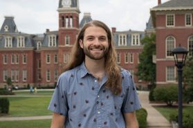 Justin Mathias stands in front of Woodburn Hall at WVU