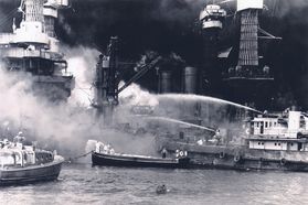 A black and white photograph showing how the USS West Virginia battleship was severely damaged and sunk in the Pacific Ocean during the Pearl Harbor attacks of World War II. 