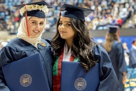 Zaynab Dashti and Mahar Alshahwaizi share a moment at the WVU commencement December 15, 2017.