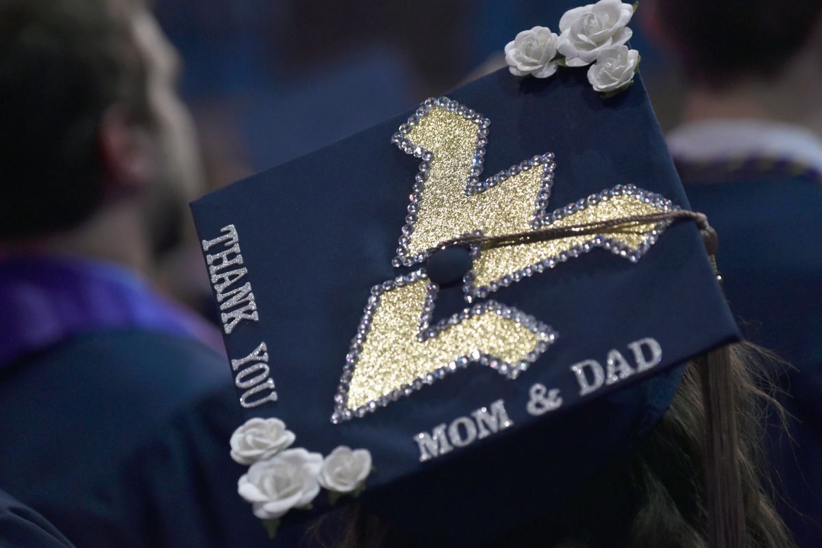Photo of the back of a navy blue WV graduation cap decorated with a big flying WV and the words 