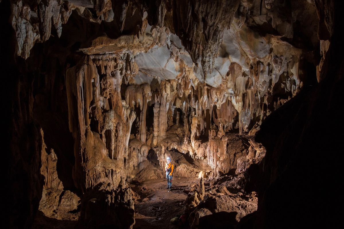woman stands inside a cave