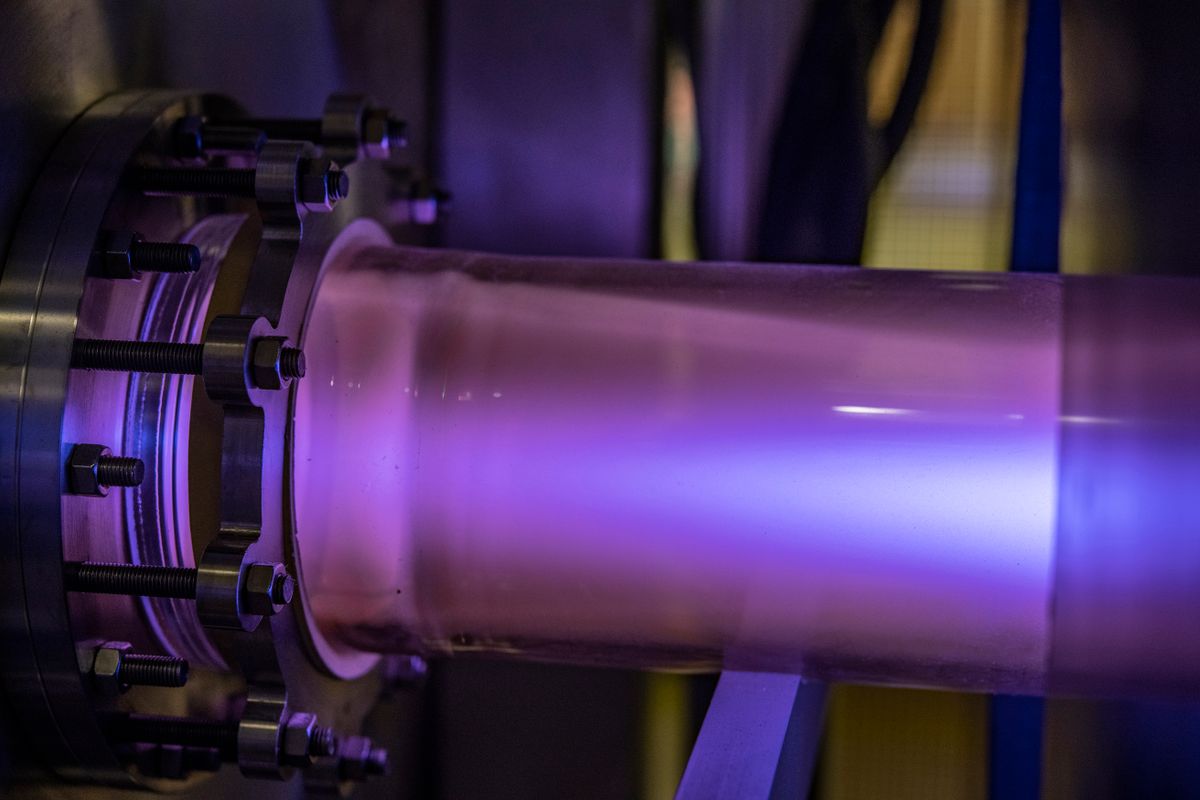 Purple plasma is shown in a clear tube stretching to both sides of the photo frame.